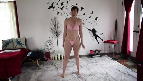 Aurora Willows stretching in a pink bikini