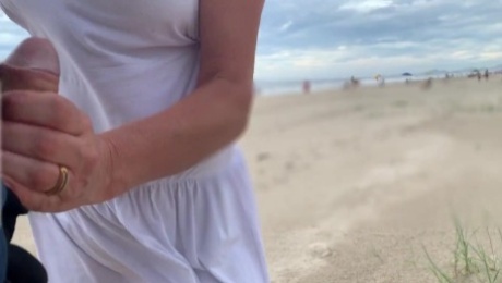 She loves to make a handjob on the crowded beach